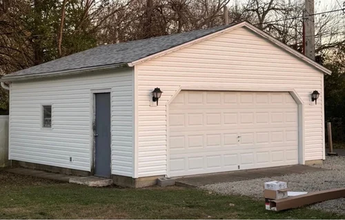 The same detached garage after the work: new roof, new siding and new trim