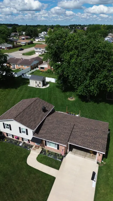 Completed brown architectural shingle roof on a split-level brick home