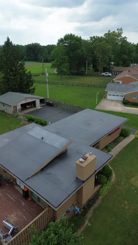 New black membrane roofing across the flat roof of a mid-century ranch home