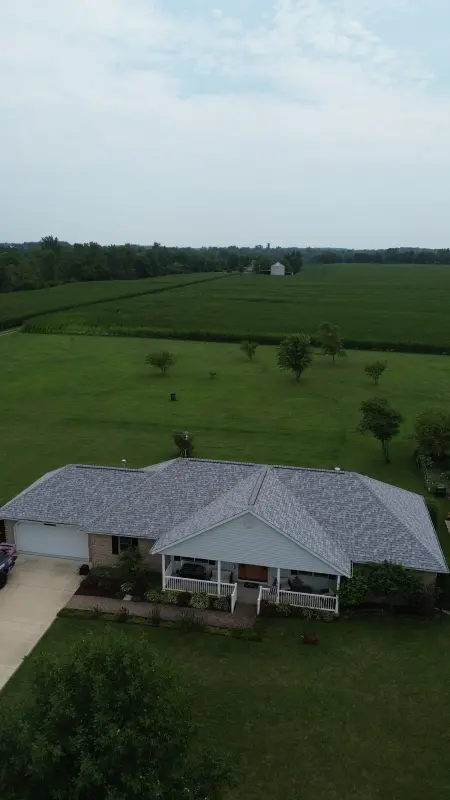 Light gray architectural shingle roof on a brick ranch home in the countryside