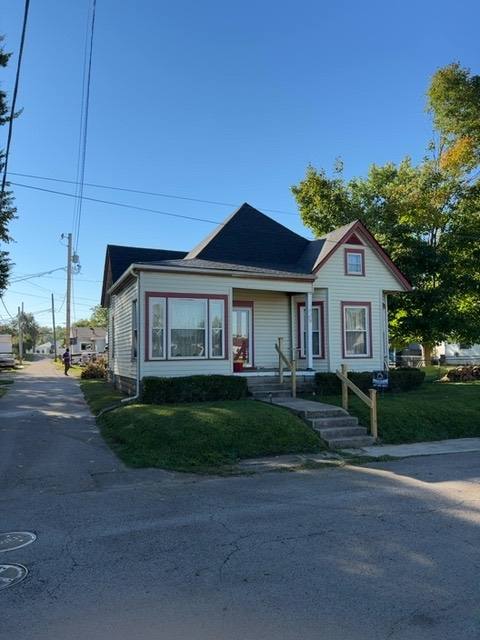 Residential home with peaked roof and flat rear section before work in Piqua