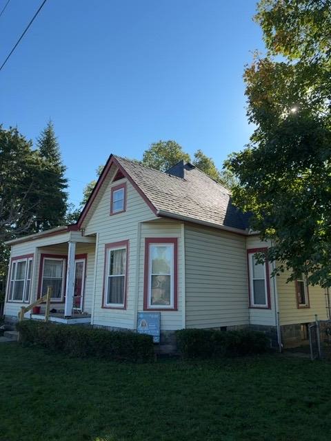 Completed peaked roof with new shingles and flat roof behind in Piqua