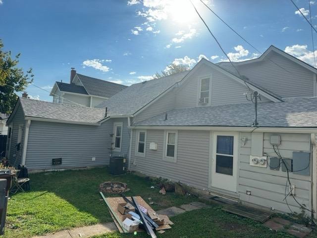 New roof installation on rear and side sections of home with completed shingle coverage in Piqua